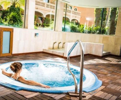 Mujer disfrutando del jacuzzi de la zona de spa del hotel.