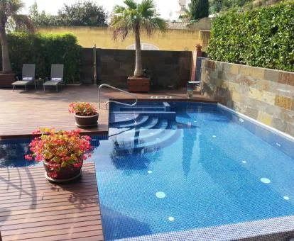 Acogedora zona exterior con piscina y solarium de este hotel con encanto.