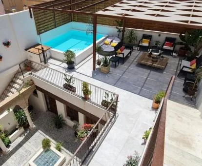 Vista aérea de este acogedor hotel boutique con terraza amueblada y piscina al aire libre.