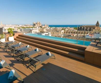 Terraza solarium con piscina y vistas a la ciudad de este hotel boutique.