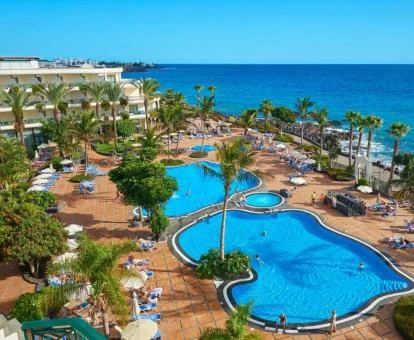 Vista aérea de este precioso hotel junto al mar y amplia zona exterior con piscinas.