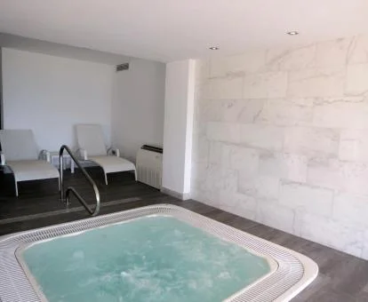 Acogedora sala de bienestar del spa con jacuzzi y zona de relajación.