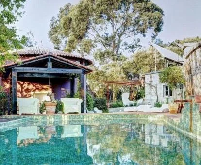 Zona exterior con piscina rodeada de bellos jardines de este hotel.
