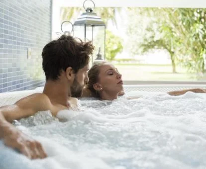 Pareja disfrutando del jacuzzi del spa del hotel. 