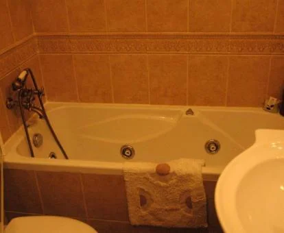 Baño con bañera de hidromasaje privada del apartamento de tres dormitorios de este establecimiento.