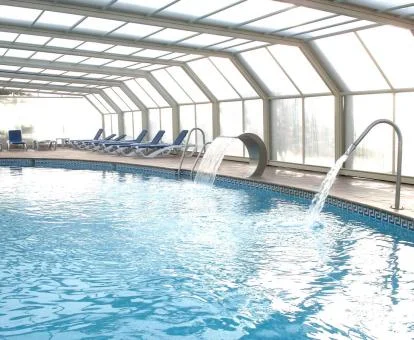 Piscina cubierta con elementos de hidroterapia del spa del hotel.