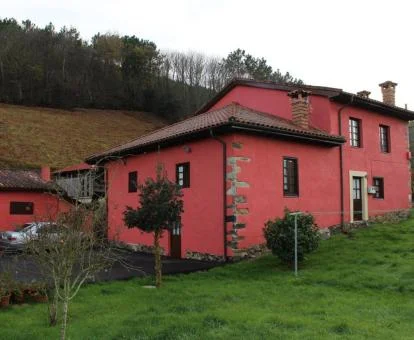 Edificio rojizo de este hotel rural solo para adultos rodeado de naturaleza.