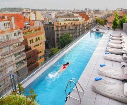 Mujer disfrutando de la piscina con vistas a la ciudad de este hotel romántico.