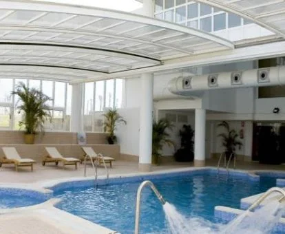Piscina cubierta con elementos de hidroterapia del spa del hotel.