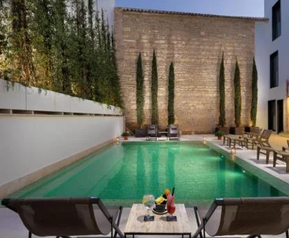 Agradable zona exterior con piscina y mobiliario del hotel.