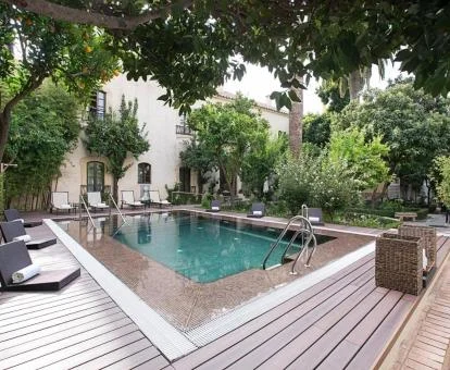 Acogedora zona exterior con piscina rodeada de jardines de este hotel romántico.