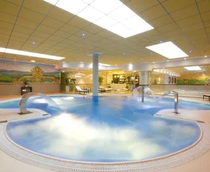 Piscina interior con elementos de hidroterapia del centro de spa del hotel.