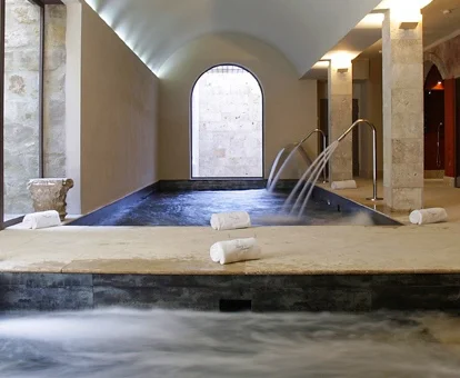 Piscina cubierta con elementos de hidroterapia del spa del hotel.