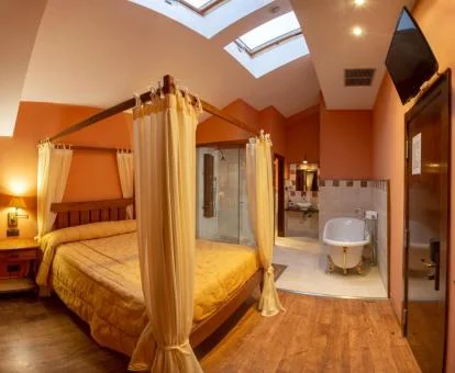 Una de las habitaciones con cama con dosel y bañera junto a la cama del hotel.