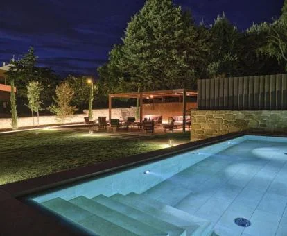 Agradable zona exterior con piscina y mobiliario en el jardín de este acogedor hotel.