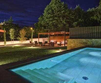 Zona exterior con piscina y mobiliario en el jardín de este romántico hotel.