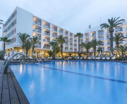 Gran piscina exterior de este hotel solo para adultos, equipada con chorros de hidroterapia y rodeada de tumbonas y palmeras.
