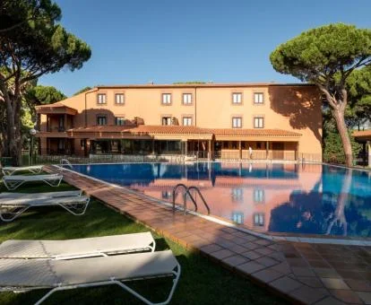 Edificio de este hotel rural con piscina y amplios jardines rodeado de vegetación.
