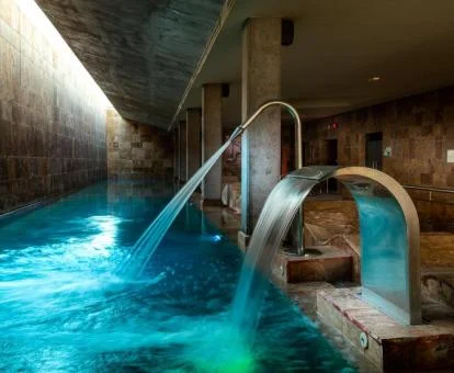 Piscina cubierta con elementos de hidroterapia en funcionamiento del spa.