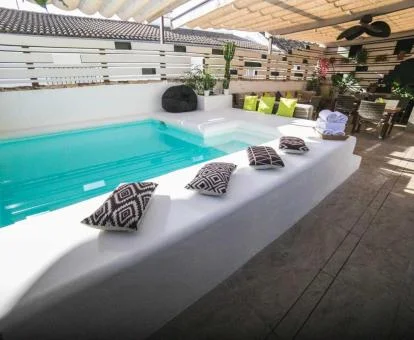Terraza comunitaria de este hotel con encanto con piscina y zonas de estar.