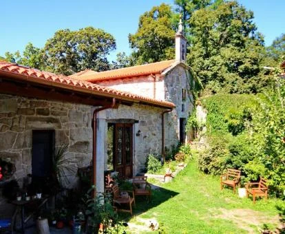 Edificio de estilo tradicional con paredes de piedra y bellos jardines de este maravilloso establecimiento.