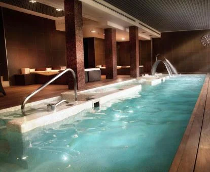 Piscina cubierta con elementos de hidroterapia del spa del hotel.