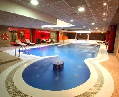 Gran piscina con elementos de hidroterapia y zona de relajación del spa.