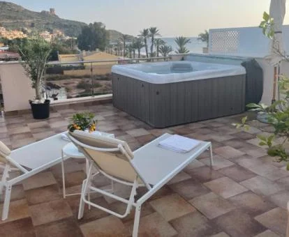 Fabulosa terraza privada con un gran jacuzzi al aire libre y vistas al mar de este apartamento.