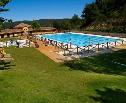 Gran piscina rodeada de jardines de este complejo de apartamentos rurales.