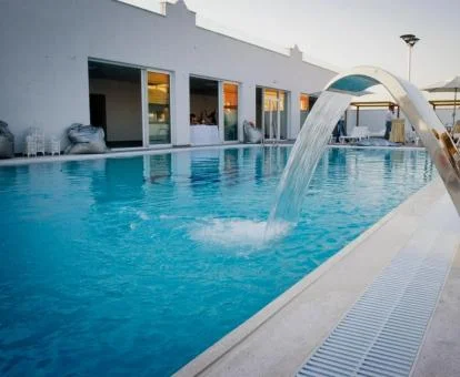 Preciosa piscina con elementos de hidroterapia al aire libre del hotel.