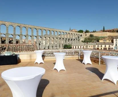 Amplia terraza con mobiliario y vistas al acueducto de Segovia de este céntrico hotel.
