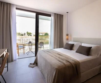 Una de las habitaciones con amplios ventanales y balcón privado del hotel.