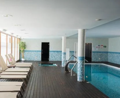 Piscina interior con zona de relajación del spa del hotel.