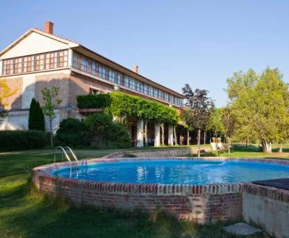 Edificio de este alojamiento rural con amplios jardines y piscina al aire libre.