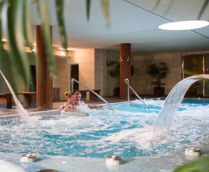 Pareja disfrutando de la zona de aguas del spa del hotel.