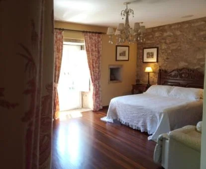 Una de las amplias habitaciones de estilo tradicional con paredes de piedra a la vista del hotel.