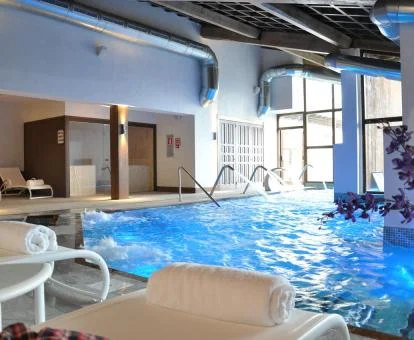 Piscina interior con chorros y zona de relajación del spa.
