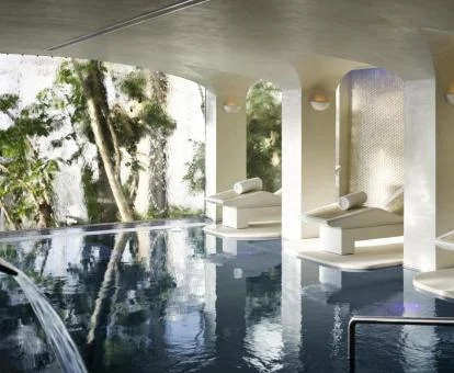 Piscina cubierts con chorros y tumbonas del spa.