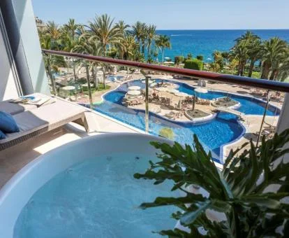 Terraza con jacuzzi privado y vistas al mar y a las piscinas de una de las habitaciones del hotel.