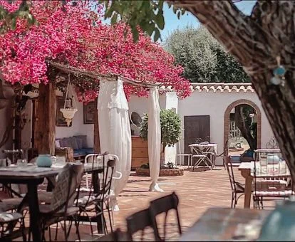 Patio interior con flores y zonas de estar de este coqueto hotel rural.