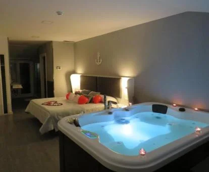 Fabulosa habitación doble deluxe con bañera de hidromasaje privada junto a la cama de este hotel rural.
