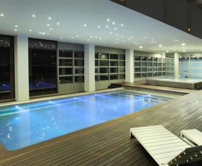 Piscina cubierta con zona de relajación y vistas a la ciudad del spa.