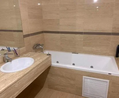Baño con bañera de hidromasaje privada de este apartamento independiente.