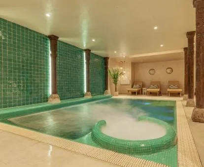 Piscina cubierta con elementos de hidroterapia del spa del hotel.