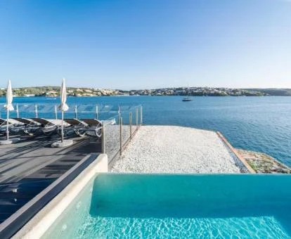 Terraza con piscina exterior de borde infinito y solarium con vistas al mar de este maravilloso hotel.
