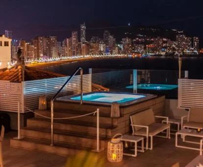 Zona exterior con iluminación nocturna de este precioso hotel solo para adultos con jacuzzi exterior.