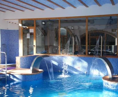 Piscina cubierta con elementos de hidroterapia del spa del hotel.