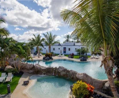 Zonas exteriores con piscinas tipo laguna y ambiente paradisíaco de este hotel solo para adultos.