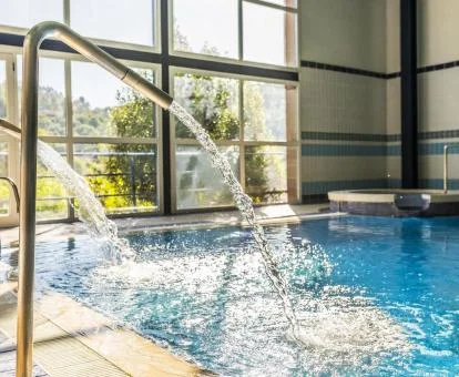 Piscina con hidroterapia y vistas al exterior del spa del hotel.
