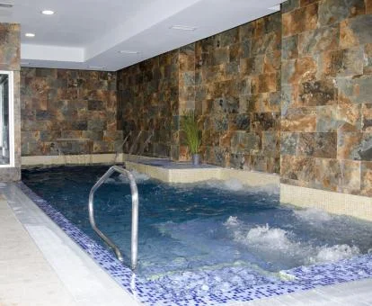Piscina cubierta con elementos de hidroterapia del spa del hotel.